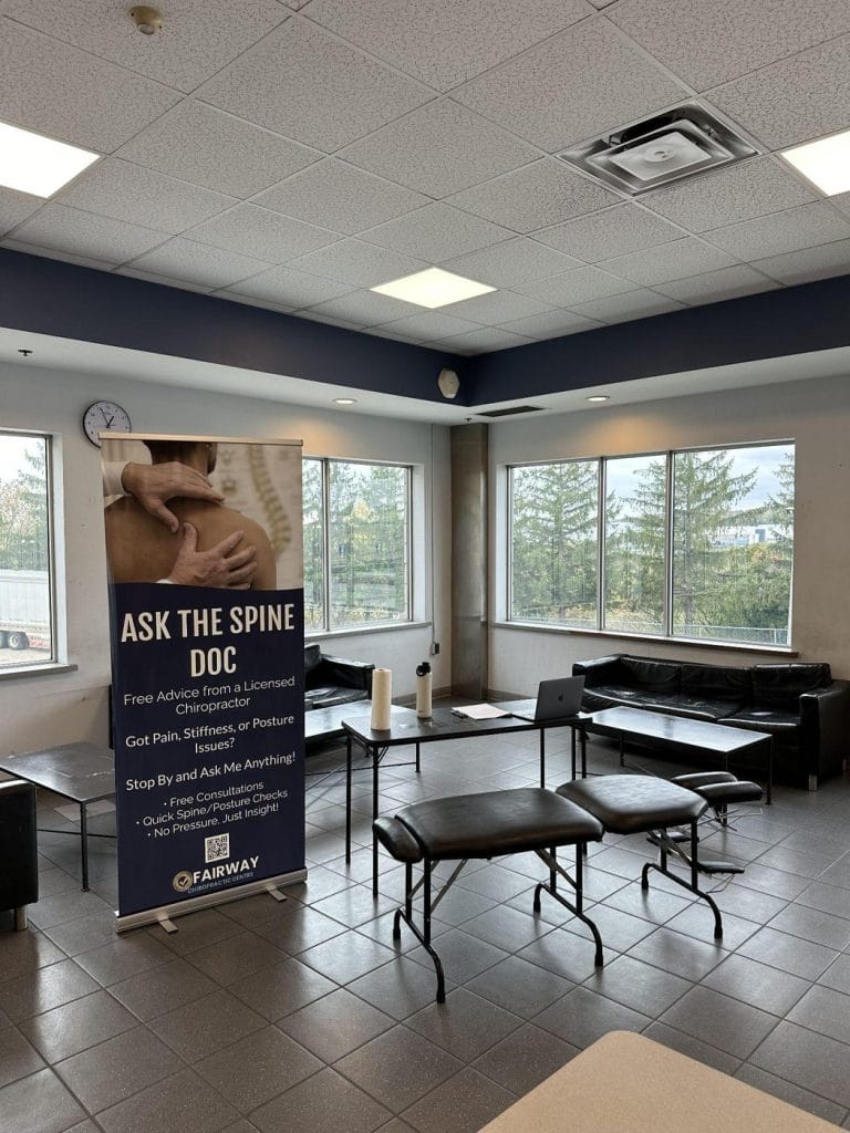 Ask the Spine Doc pull up banner and massage table set up in a workplace lounge